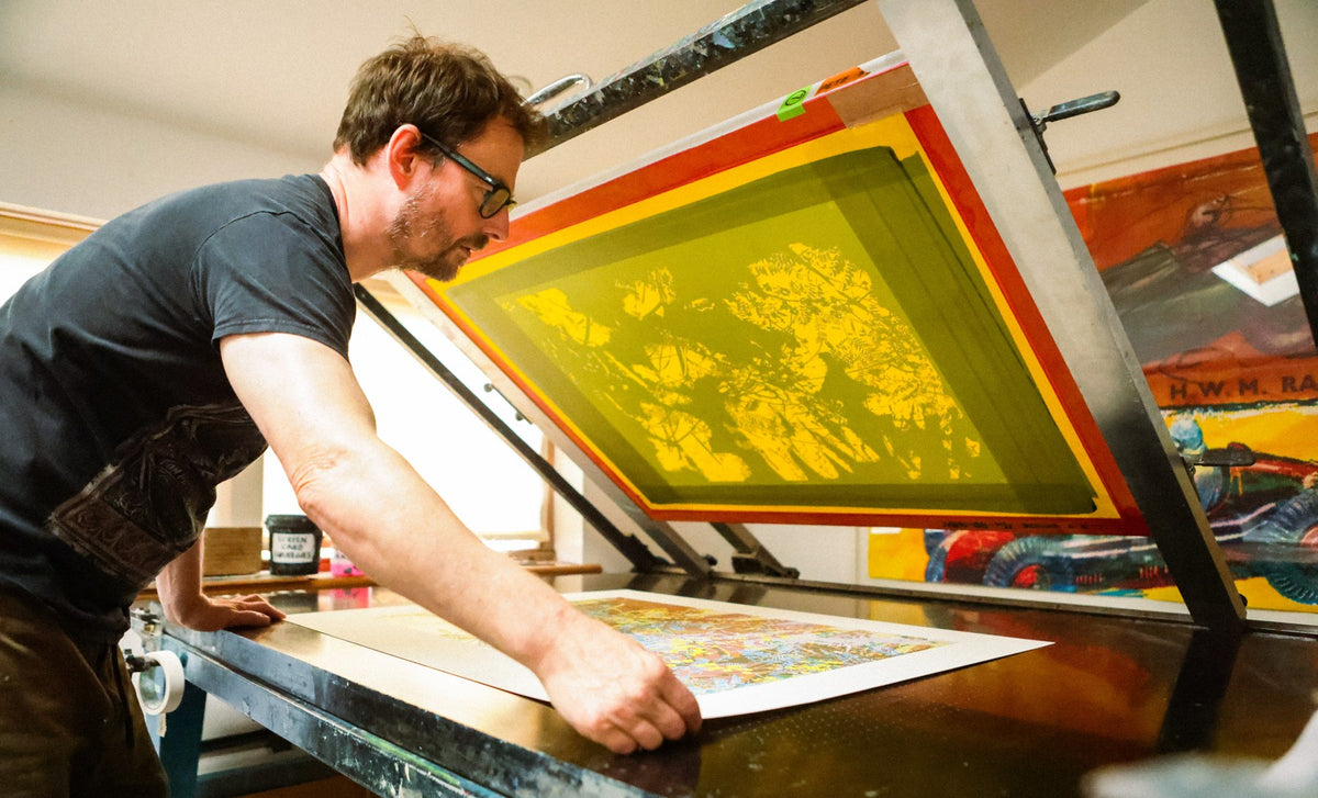 Pete Shuttleworth hebt in seinem Studio in Brighton das Sieb von einem gelben Druck (Foto: Sim Warren)