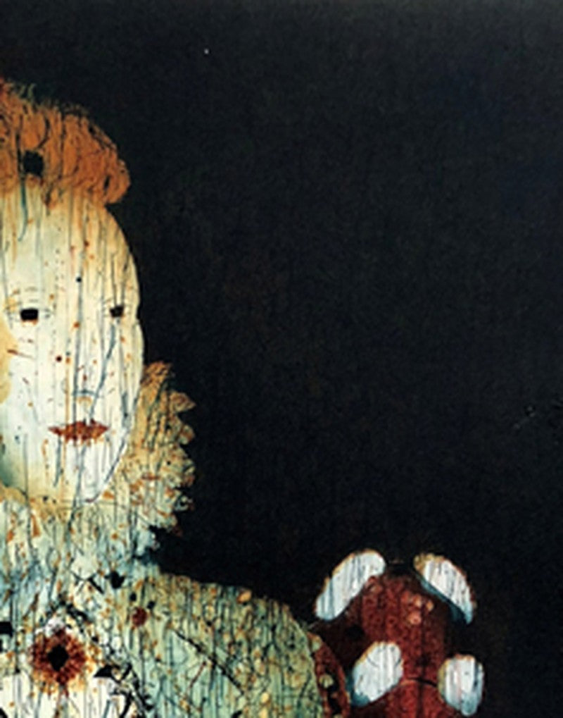 Detail: Detail einer Figur mit blassem Gesicht und rotgemustertem Ärmel vor schwarzem Hintergrund.