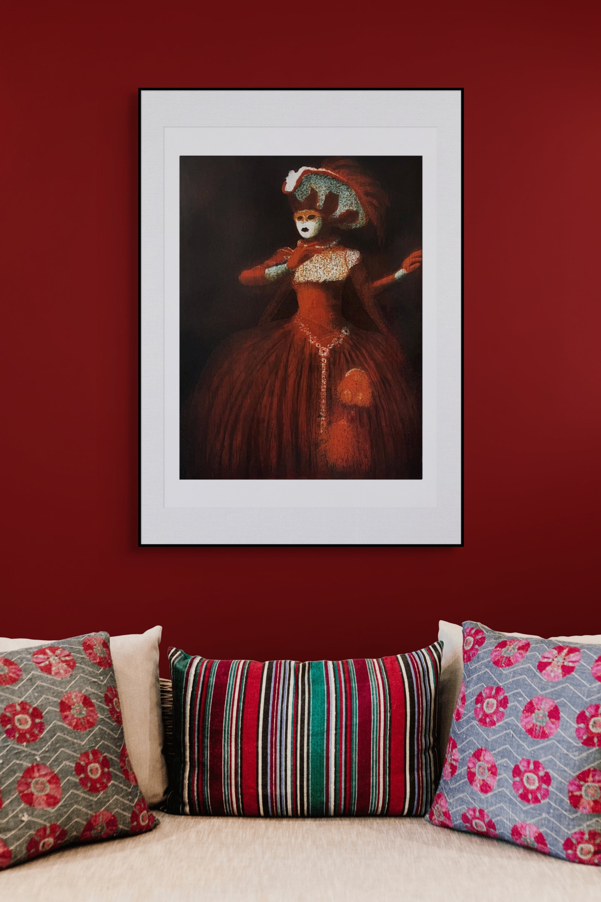 Gerahmte Radierung "Venetian" von Stephen Lawlor – Gerahmtes Bild an weinroter Wand über Sofa mit gemusterten Kissen in Rot, Rosa und Grün.