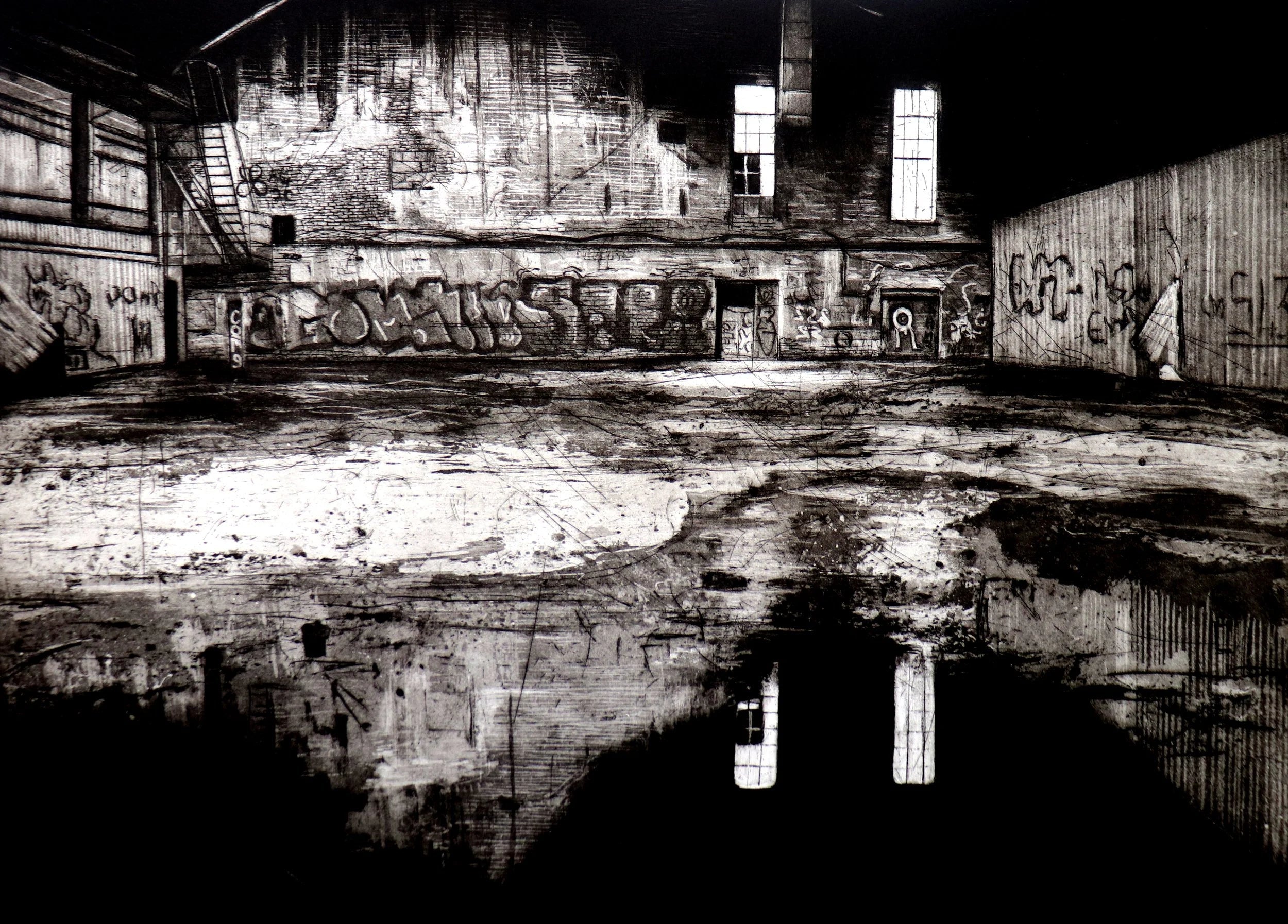 Gerahmte Radierung "Permanite Asphalt Works III" von Jemma Gunning – Verlassener Industriehof mit Graffiti an der Wand und Pfützen-Spiegelung der Fe.